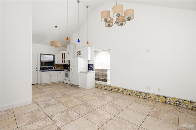 kitchen with white appliances, high vaulted ceiling, white cabinets, a chandelier, and hanging light fixtures