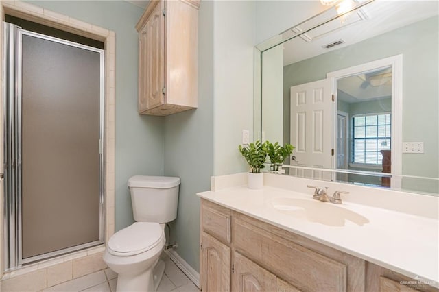 bathroom featuring tile patterned flooring, vanity, toilet, and a shower with shower door