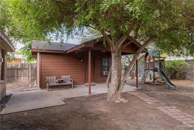 rear view of property with a patio and a playground