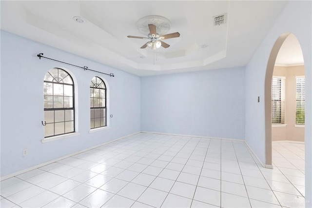 2915 Roselawn Dr, Weslaco, TX 78596 - spare room with ceiling fan, a tray ceiling, arched walkways, and plenty of natural light