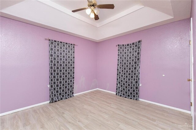 2915 Roselawn Dr, Weslaco, TX 78596 - unfurnished room with a tray ceiling, a ceiling fan, and wood finished floors