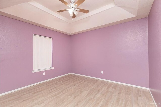 2915 Roselawn Dr, Weslaco, TX 78596 - unfurnished room featuring a tray ceiling, light wood finished floors, and ceiling fan