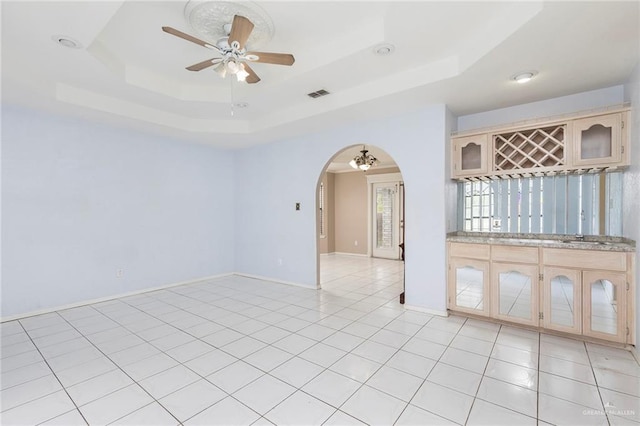 2915 Roselawn Dr, Weslaco, TX 78596 - unfurnished room with arched walkways, ceiling fan, bar area, and a raised ceiling