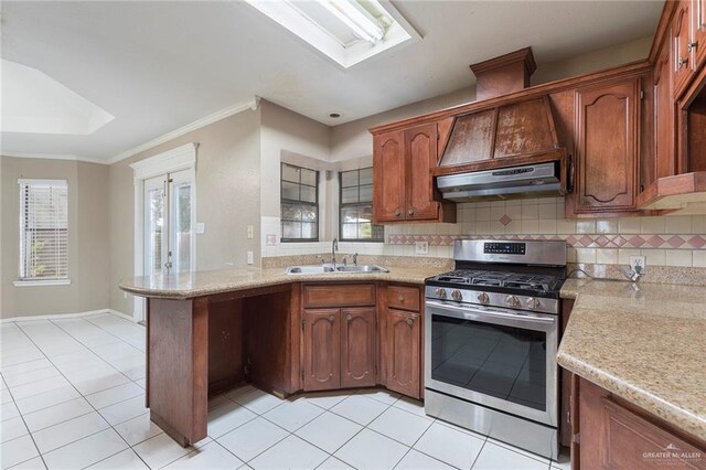 2915 Roselawn Dr, Weslaco, TX 78596 - kitchen featuring stainless steel gas range, a peninsula, light tile patterned floors, under cabinet range hood, and ornamental molding