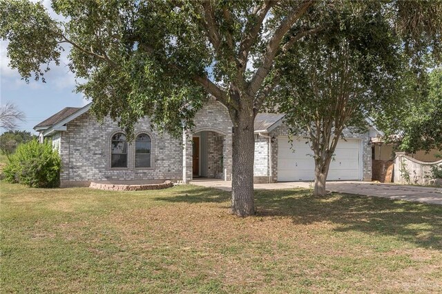 2915 Roselawn Dr, Weslaco, TX 78596 - view of front of house with asphalt driveway, an attached garage, a front lawn, and brick siding