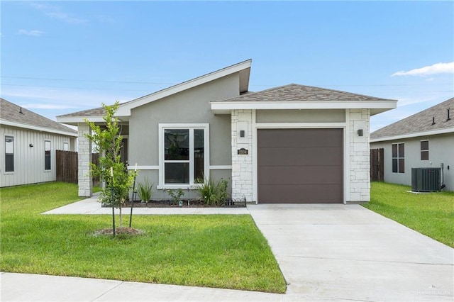 ranch-style home featuring a front yard, a garage, and central air condition unit