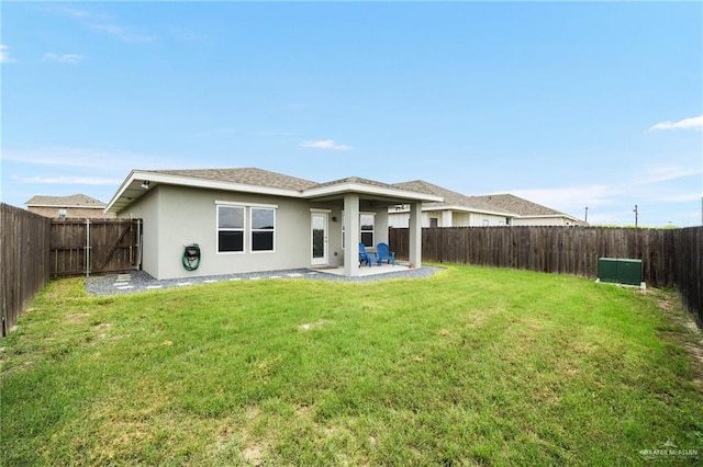 rear view of property featuring a yard and a patio area