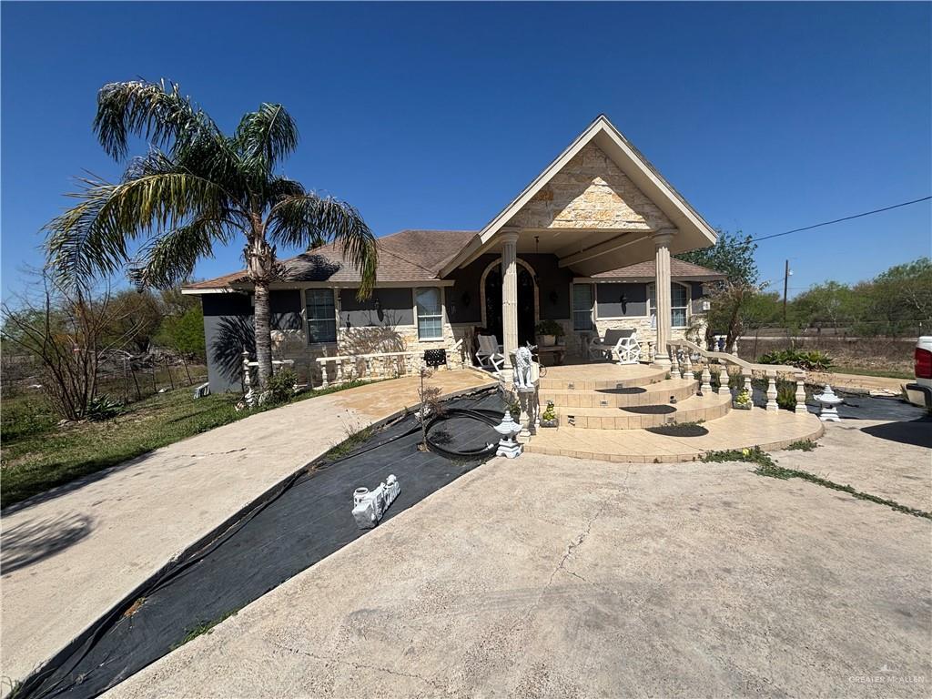 ranch-style house featuring stone siding