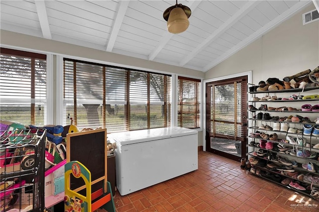 sunroom with a wealth of natural light, lofted ceiling with beams, and wooden ceiling