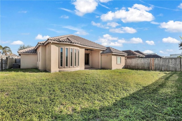 back of property featuring a lawn and central AC unit