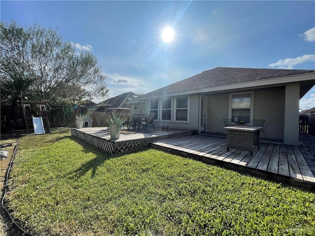 rear view of property with a lawn and a wooden deck