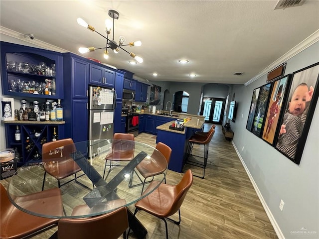 dining room featuring a chandelier, hardwood / wood-style floors, crown molding, and sink