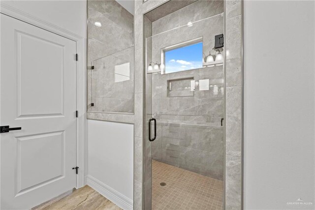 bathroom with hardwood / wood-style flooring and a shower with shower door