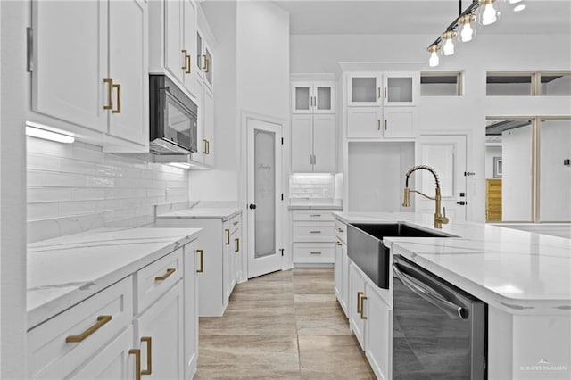 kitchen featuring stainless steel dishwasher, sink, decorative light fixtures, a center island with sink, and white cabinets