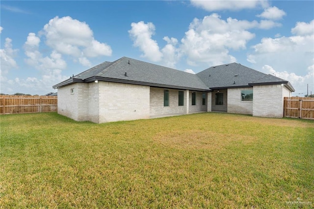 rear view of property with a yard