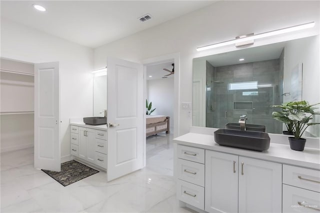 bathroom with ceiling fan, a shower with door, and vanity