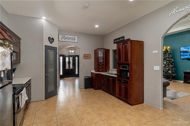 kitchen featuring light tile patterned floors and range with electric cooktop