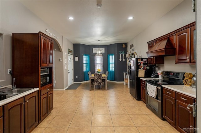 kitchen featuring sink, black fridge, decorative light fixtures, stainless steel range with electric cooktop, and custom exhaust hood