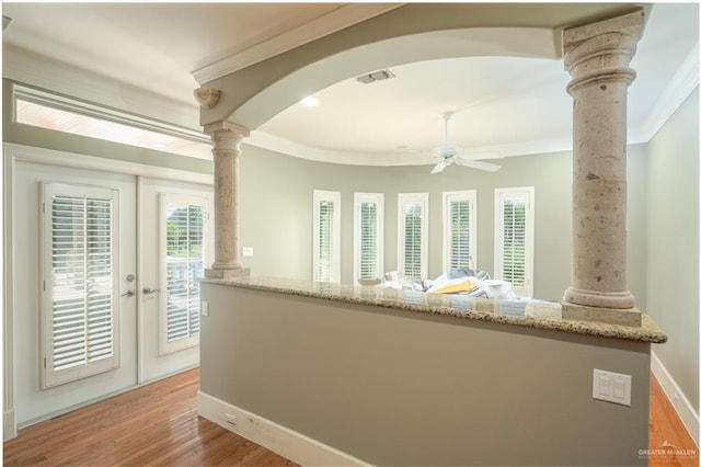 interior space with french doors, light wood-type flooring, decorative columns, and crown molding