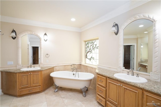 bathroom with tile patterned floors, vanity, a bathtub, and crown molding