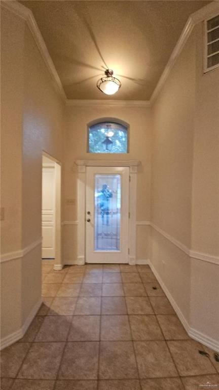 entrance foyer featuring ornamental molding and tile patterned floors