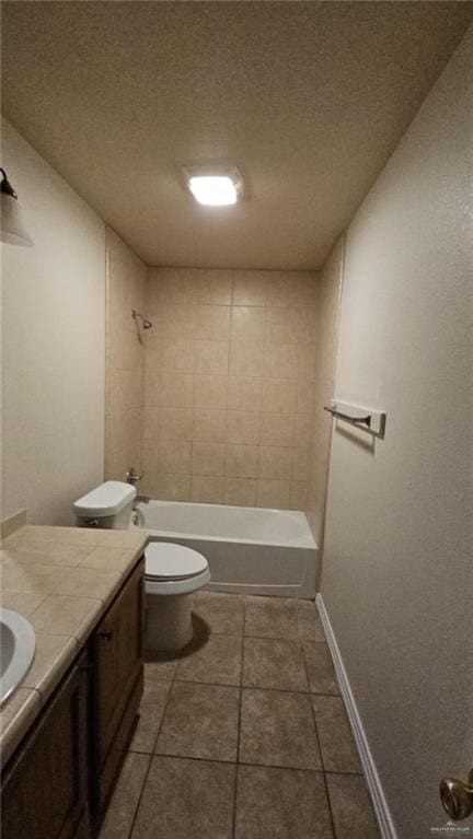 full bathroom with a textured ceiling, tiled shower / bath, toilet, tile patterned floors, and vanity