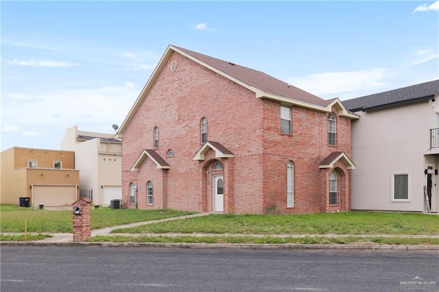 view of front of house with central AC, brick siding, and a front lawn