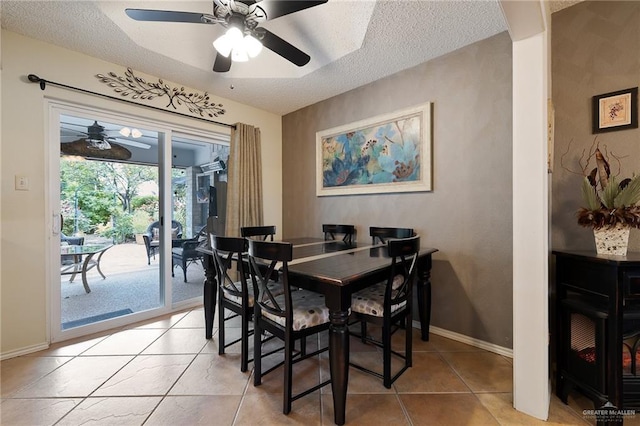 dining area with a textured ceiling, tile patterned floors, and ceiling fan