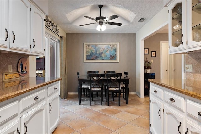 tiled dining room with ceiling fan and a textured ceiling