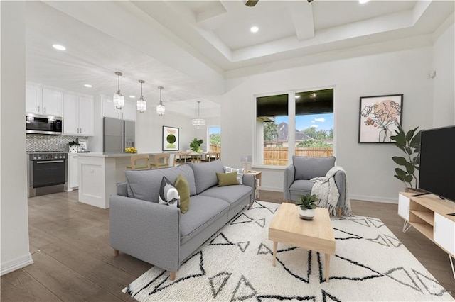 living room with light wood-type flooring and a tray ceiling