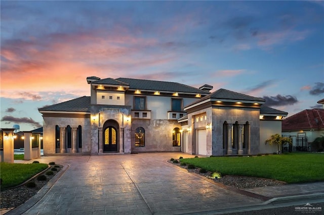 view of front of home with a garage and a lawn