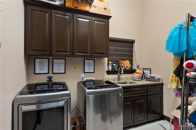 laundry room featuring washing machine and clothes dryer, sink, and cabinets