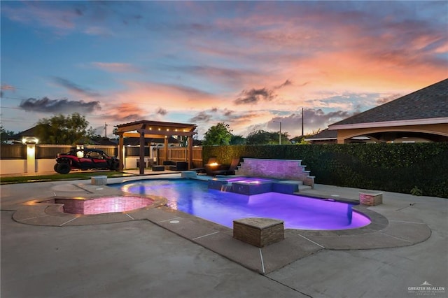 pool at dusk with a patio area and an in ground hot tub