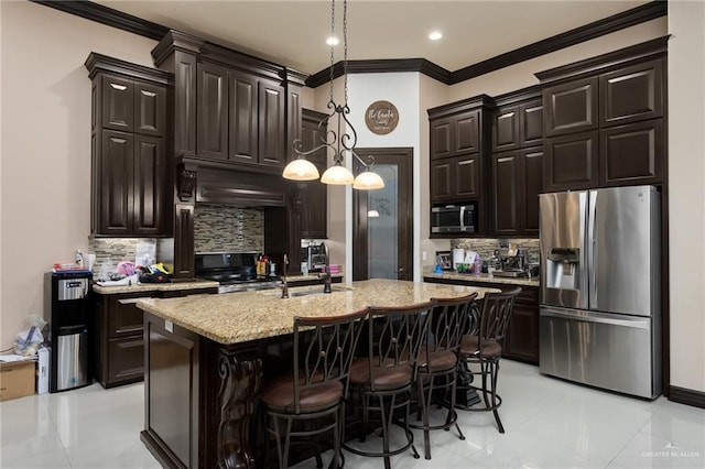 kitchen featuring backsplash, a center island with sink, pendant lighting, and appliances with stainless steel finishes