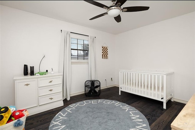 bedroom with ceiling fan, dark hardwood / wood-style flooring, and a crib