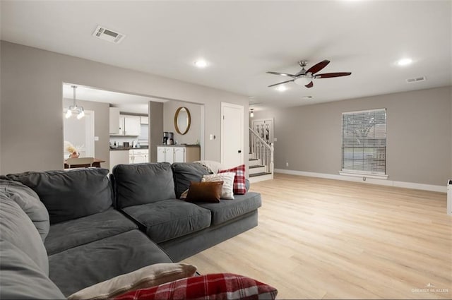 living room with light wood-type flooring and ceiling fan