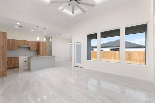 unfurnished living room with ceiling fan