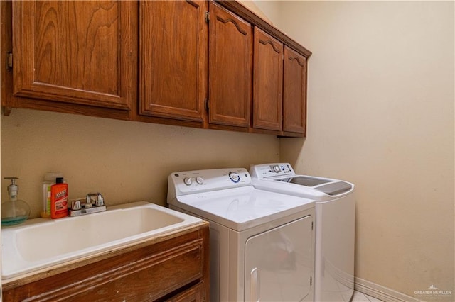 laundry room featuring cabinets, independent washer and dryer, and sink