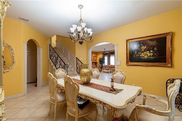 tiled dining area featuring ornate columns and an inviting chandelier