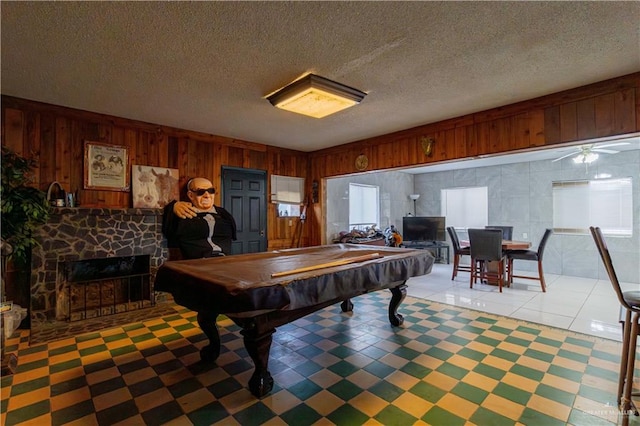 recreation room with a textured ceiling, pool table, and wood walls