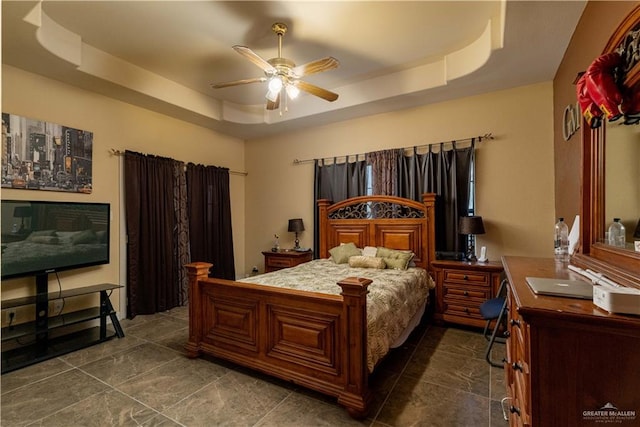 bedroom with a tray ceiling and ceiling fan