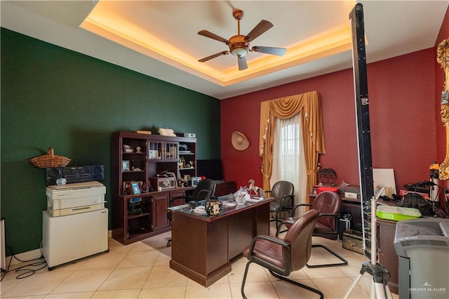 office area with ceiling fan, light tile patterned flooring, and a tray ceiling