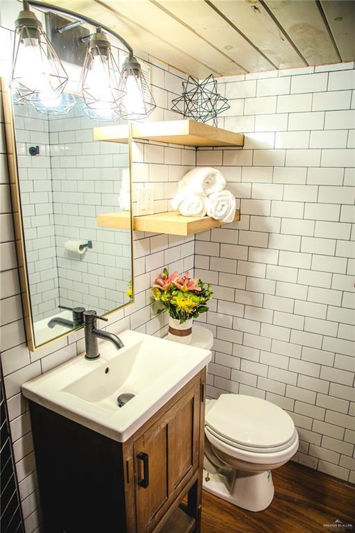 420 N Mayberry Rd, Alton, TX 78573 - bathroom featuring tile walls, wood finished floors, and vanity