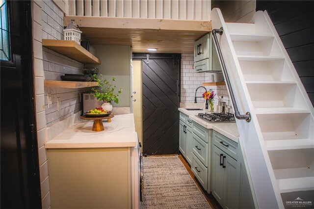 420 N Mayberry Rd, Alton, TX 78573 - kitchen featuring open shelves, light countertops, backsplash, stainless steel gas stovetop, and wooden walls