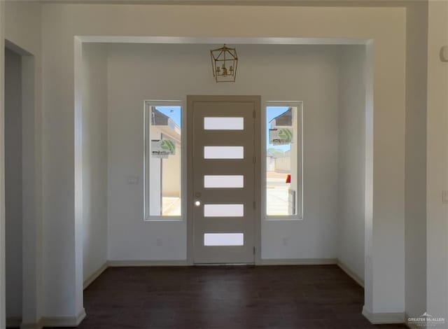 foyer with a notable chandelier and dark hardwood / wood-style flooring