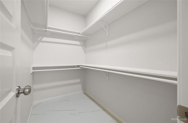 spacious closet featuring marble finish floor