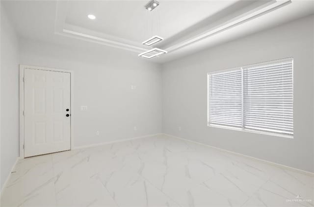 unfurnished room with visible vents, baseboards, marble finish floor, a tray ceiling, and recessed lighting