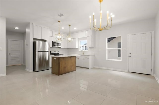 kitchen featuring stainless steel appliances, a center island, a chandelier, and white cabinets