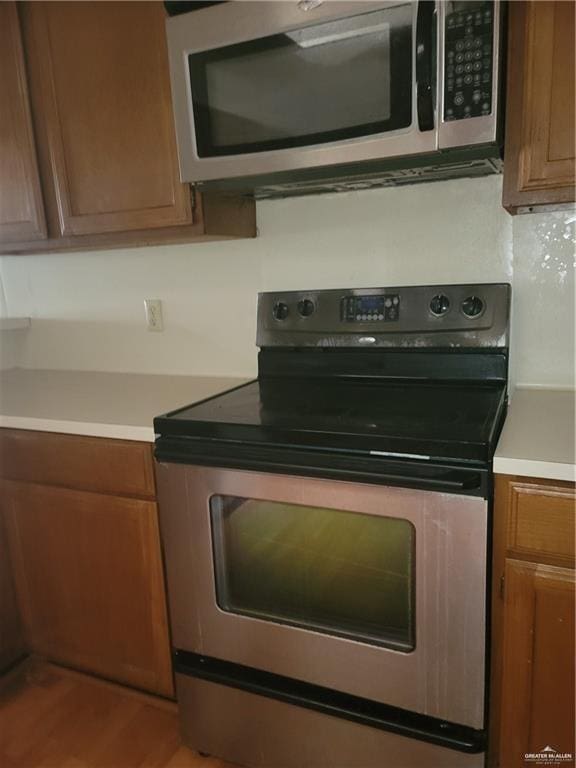 kitchen with stainless steel appliances and hardwood / wood-style flooring