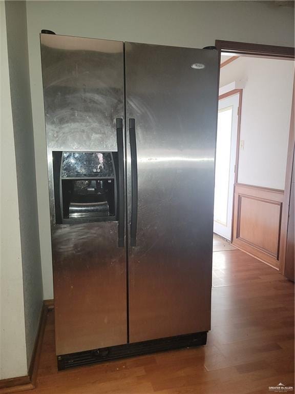 room details with stainless steel refrigerator with ice dispenser and hardwood / wood-style floors